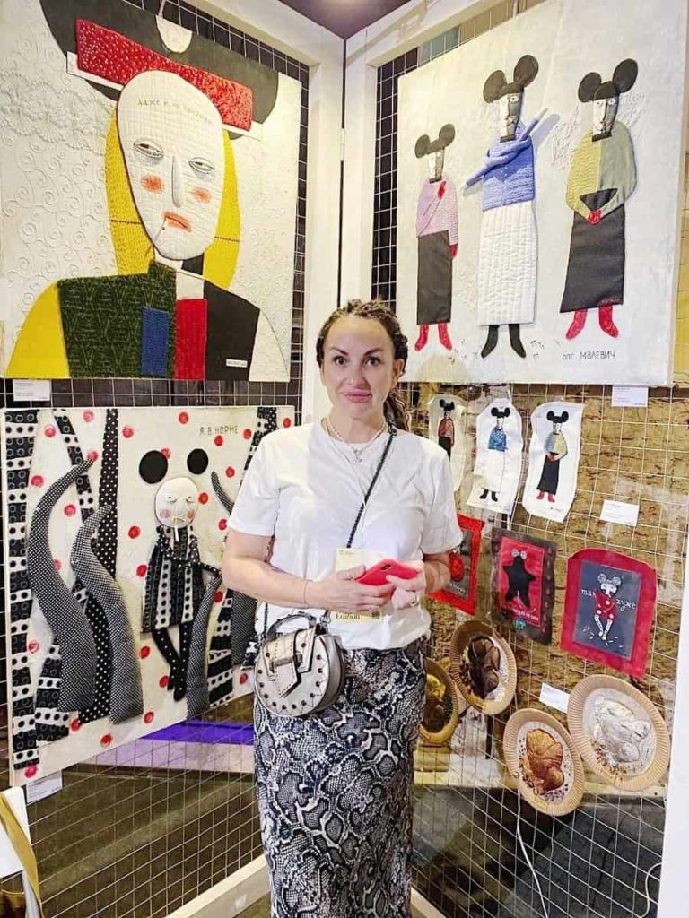 Une artiste sur son stand d’œuvres textiles